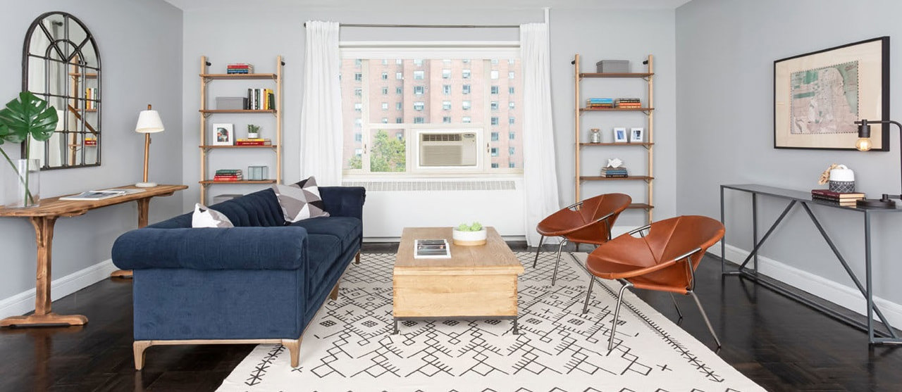 Living Room with blue couch, orange leather chairs, pattern rug