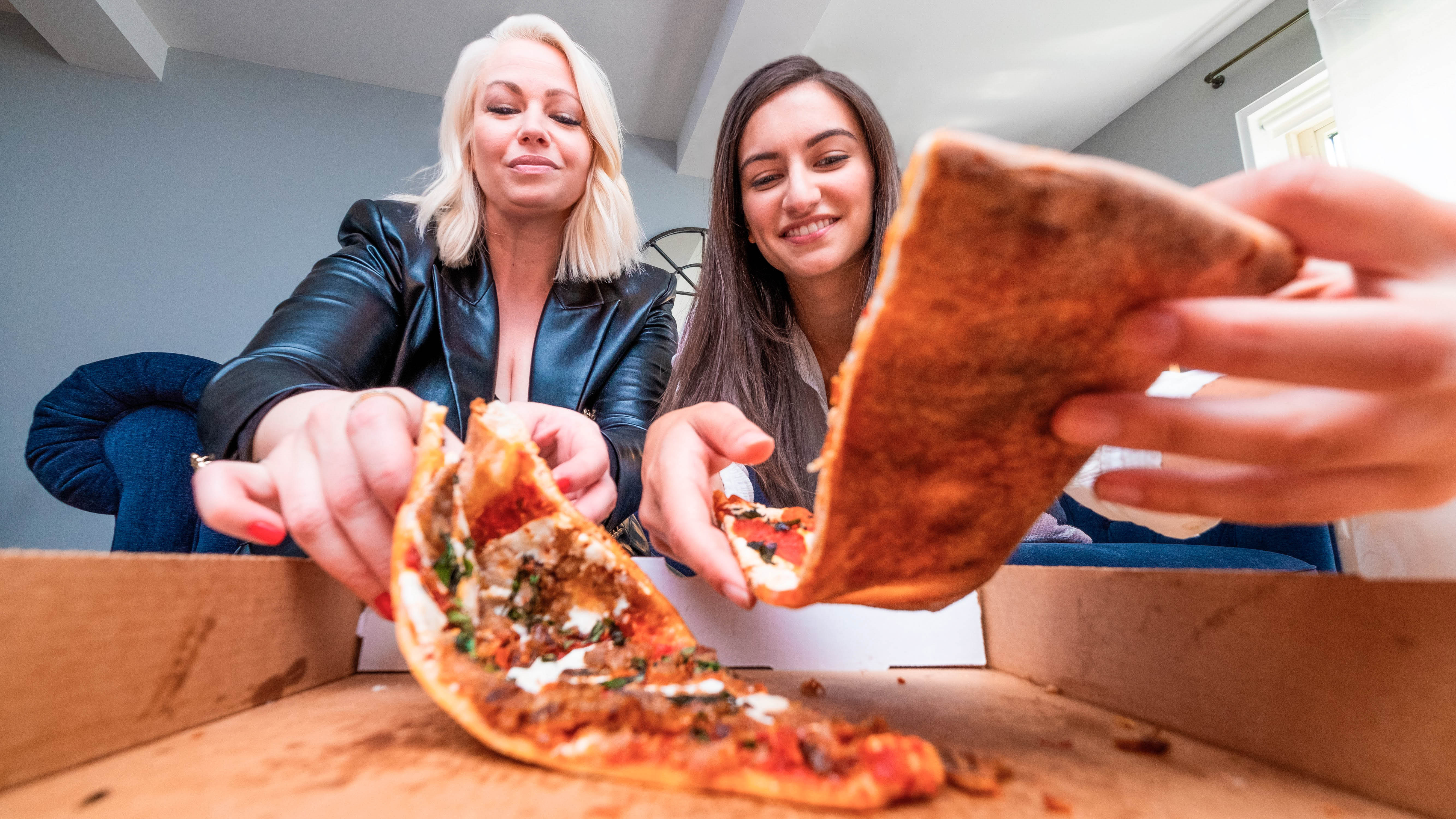 Two women eating pizza